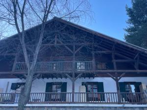 een groot houten huis met een balkon erop bij BodyGo Briançon in Briançon