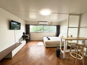 a bedroom with a bed and a desk and a table at Lykke Room Poppular Condo P1 in Ban Bang Phang