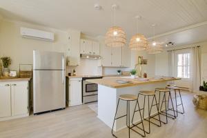 三河城Séjour zen au Bor de l'eau的厨房配有白色冰箱和酒吧凳