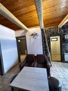 un soggiorno con tavolo e sedie e un muro di pietra di Borjomi Cottages in tsemi a Patara-Tsemi