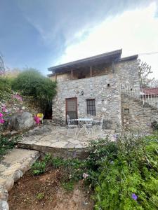 a stone house with a table and chairs in front of it at Zeytin in Datca