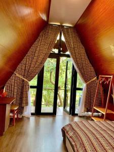 ein Schlafzimmer mit einem Bett und einem großen Fenster in der Unterkunft Buôn Gơ Rin in Láng Lớn