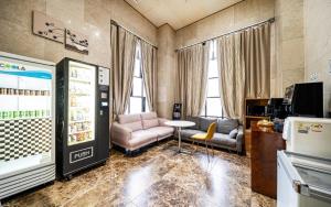 首尔Jardin Hotel的带电视、沙发和桌子的客厅