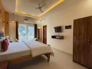 a bedroom with a bed and a tv on the wall at Rootz in Dehradun