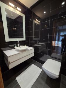 a bathroom with a sink and a toilet and a mirror at Luxury 1 bedroom at La marina in Casablanca