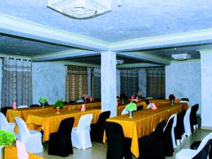 a banquet hall with yellow tables and white chairs at Psalms Motel in Entebbe