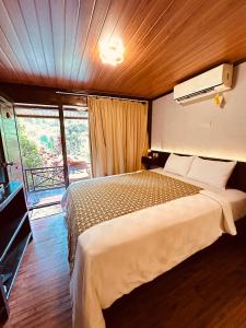 um quarto com uma cama em um quarto com janela em Puunee Wild River Villa's Borobudur em Borobudur