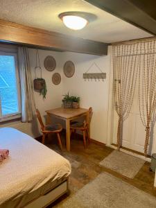 a bedroom with a table and a bed and a table and chairs at Cozy Room in an old Farmhouse near Vaduz in Sevelen +9 photos