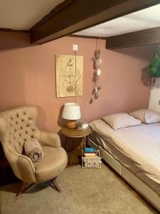 a bedroom with a bed and a chair at Cozy Room in an old Farmhouse near Vaduz in Sevelen