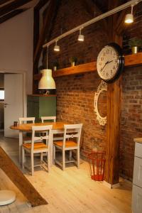 uma sala de jantar com um relógio numa parede de tijolos em Bb's Cosy Apartments em Braşov