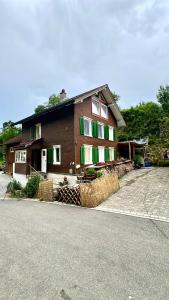 a house with green and white windows and bales of hay at Cozy Room in an old Farmhouse near Vaduz in Sevelen