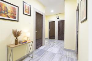 a hallway with a door and a table with a lamp at FabHotel Olive Inn I - 260m from Saltlake Sector V Metro Station in Kolkata