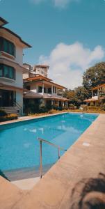 a blue swimming pool in front of a building at Cabatales - 3BHK Villa Near Candolim Beach in Candolim