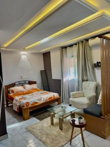 Un dormitorio con una cama, una silla y una mesa. en Résidence Karima, en Abiyán
