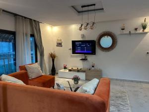 Una sala de estar con un sofá y un televisor. en Résidence Karima, en Abiyán