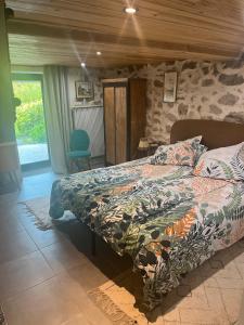 una camera da letto con un letto e un muro di pietra di Le Carnotzet Du Lac - Hauts D'evian a Larringes