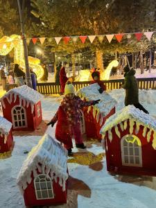 Un niño está jugando en la nieve frente a casas de jengibre. en Shgedi Mestia, en Mestia