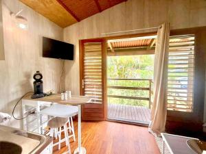 TV a/nebo společenská místnost v ubytování Ti Nid Salazie, Bungalow créole et vue montagne + 8 fotografií