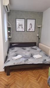 a bedroom with a bed with three pictures on the wall at Apartman 43 in Kraljevo