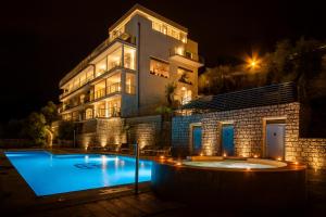 a house with a swimming pool at night at Hotel Benacus Panoramic in Riva del Garda