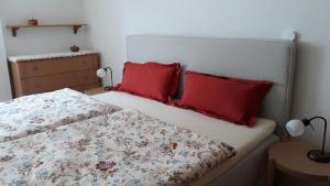Un dormitorio con una cama con dos almohadas rojas. en Ferienhaus in Mehring, en Mehring
