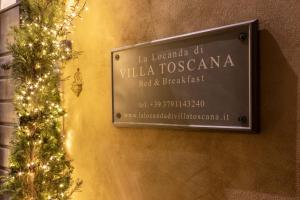 un cartel en una pared con un árbol de Navidad en La Locanda di Villa Toscana, en Bibbona