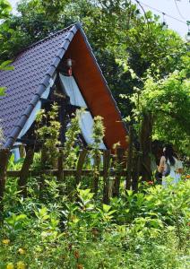 eine Frau sitzt vor einem Haus in der Unterkunft Buôn Gơ Rin in Láng Lớn