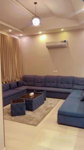 a living room with a blue couch and a table at شاليهات الفيّا in Khamis Mushayt