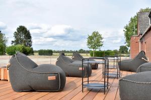 Campingfass im Naturresort Weserinsel في Langwedel: مجموعة من الكراسي والطاولات على السطح