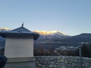 a white building with a mountain in the background at Location Appartement Les Ondes in Albertville