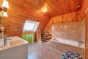 a bathroom with a tub and a sink at Maison pour 6 avec grand jardin - proche centre in Plouguerneau