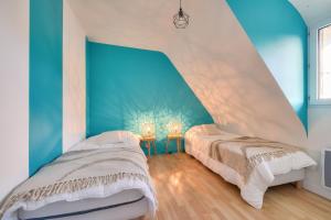 two beds in a room with blue and white walls at Maison pour 6 avec grand jardin - proche centre in Plouguerneau