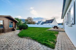 a backyard with a bench and a white fence at Maison pour 6 avec grand jardin - proche centre in Plouguerneau