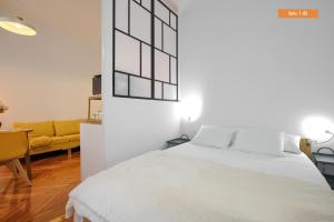 a bedroom with a white bed and a yellow couch at MEZZANINE ORANGE in Madrid