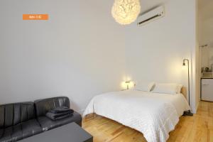 a bedroom with a bed and a black leather couch at MEZZANINE ORANGE in Madrid +26 photos
