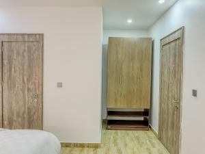 a bedroom with two wooden cabinets and a bed at Blooms Manor Apartments in Lagos