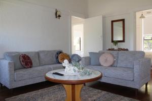 een woonkamer met een blauwe bank en een tafel bij Nonna's Cottage  +2 foto's