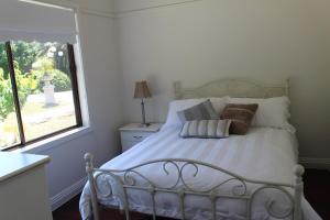 een slaapkamer met een wit bed met kussens en een raam bij Nonna's Cottage 