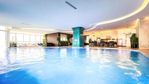a large swimming pool in a hotel lobby at Cozy modern studio with Gym & Pool in Hanoi