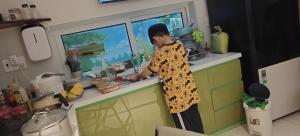 归仁Hotel Thien Hai的一名男子站在厨房准备食物