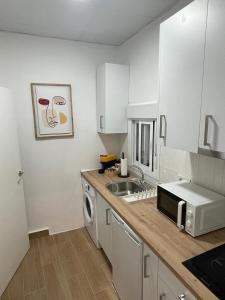 eine Küche mit Spüle und Mikrowelle in der Unterkunft Apartamento Mamalú Jerez in Jerez de la Frontera