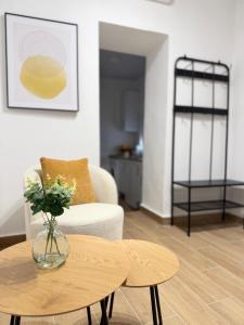 ein Wohnzimmer mit einer Vase mit Blumen auf einem Tisch in der Unterkunft Apartamento Mamalú Jerez in Jerez de la Frontera