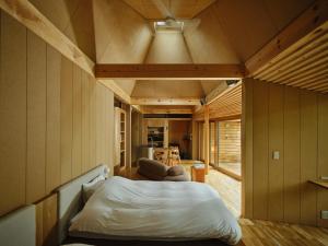 a bedroom with a bed and a living room at SANU 2nd Home Tateshina1st in Chino