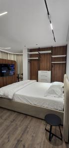 una camera da letto con un letto grande e una sedia di STAY-FIVE Cozy Modern Studios in Tirana Center - Brand New a Tirana
