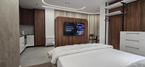 una camera da letto con un letto bianco e una cucina di STAY-FIVE Cozy Modern Studios in Tirana Center - Brand New a Tirana