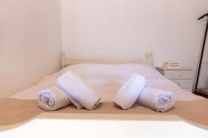 a bed with two rolled towels on it at The courtyard house in Dhimínion