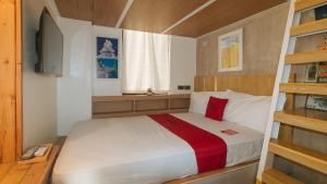 a bedroom with a bed with a red pillow at RedDoorz at Anton's Loft Designer Resort Pansol Calamba Laguna in Laguna +58 photos