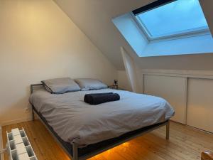 une chambre avec un lit avec une grande lucarne dans l'établissement La Terrasse du Havre, au Havre