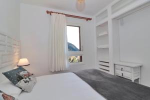 a white bedroom with a bed and a window at Apartarent 1500 - Apartamento Sanglier in Naut Aran