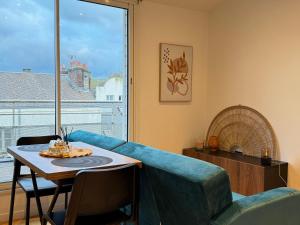 un salon avec un canapé bleu et une table dans l'établissement La Terrasse du Havre, au Havre